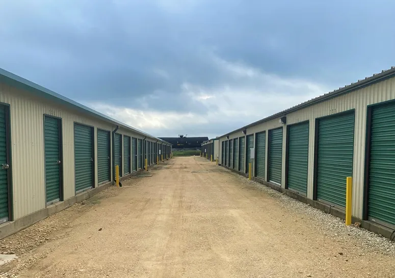 Wide drive aisle and rows of roll-up storage units at Rio Vista Mini Storage.