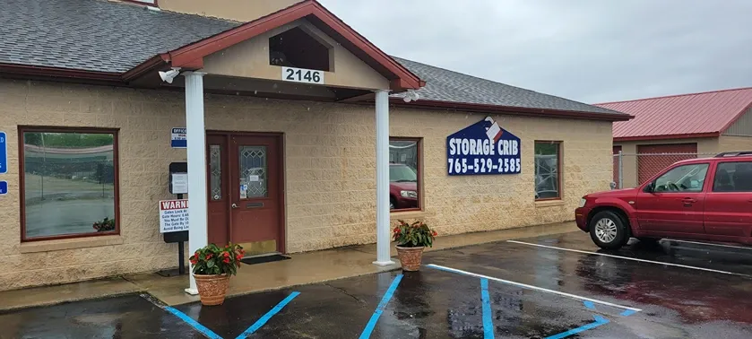 Covered entryway and building facade at Storage Crib with car parked in front.