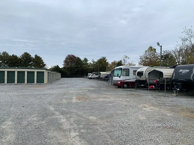 Long rows of drive-up storage units and vehicle storage with gravel access at Volunteer Storage Tellico Village.
