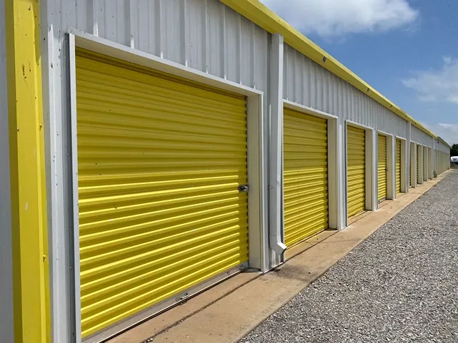 Gravel road in front of roll up door storage units at Vernon Self Storage.